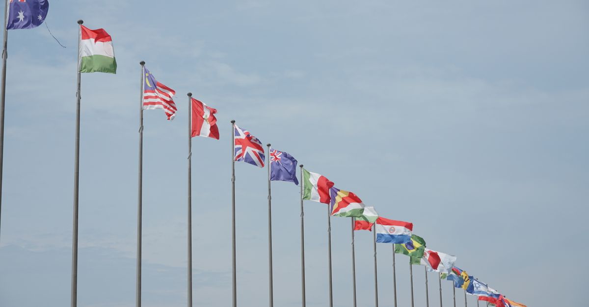 A row of international flags on flagpoles symbolizing global unity and diplomacy.